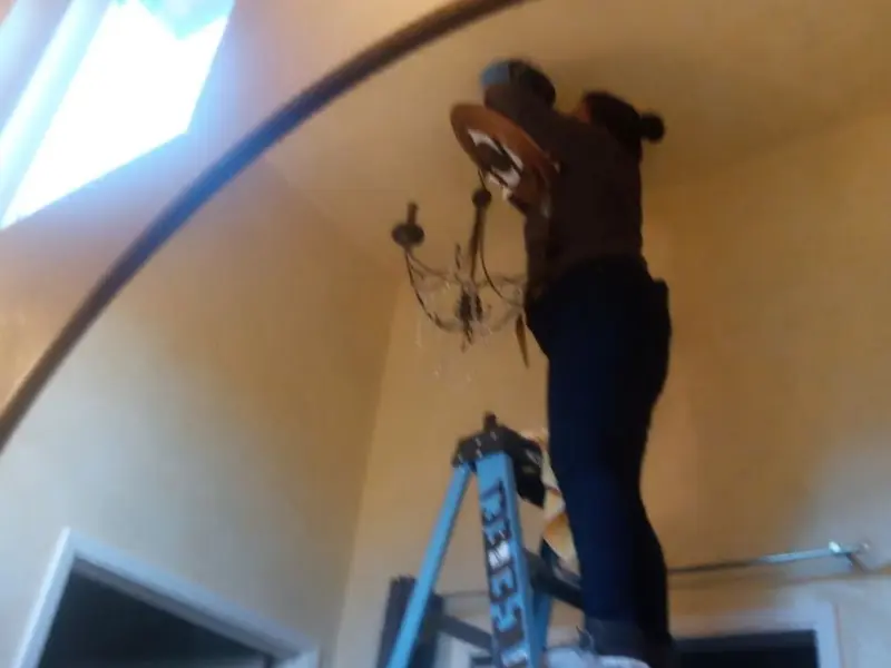 Electrician installing a chandelier in a North Canton residence